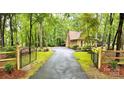 View of the gated driveway leading up to a beautiful home surrounded by lush greenery at 3214 Tilley Morris Rd, Matthews, NC 28105