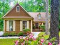 Charming exterior of a wood sided home with meticulously landscaped front yard and inviting entryway at 3214 Tilley Morris Rd, Matthews, NC 28105
