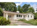 A bright, white home with a blue door and well-maintained landscaping at 4017 Sulkirk Rd, Charlotte, NC 28210