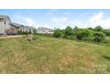 Expansive backyard featuring lush green grass, a black metal fence, and thoughtfully designed garden beds at 4912 Grace View Dr, Pineville, NC 28134