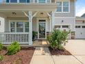Close-up of a home's front porch with a charming welcome wreath and beautifully landscaped surroundings at 4912 Grace View Dr, Pineville, NC 28134