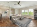 Bright living room features wood floors, neutral walls, and large windows overlooking the landscaped outdoors at 4912 Grace View Dr, Pineville, NC 28134