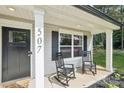 Inviting front porch with two rocking chairs and a storm door entrance featuring a lovely place to sit and relax at 507 Newsome Rd, Salisbury, NC 28146