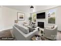 Bright living room featuring a fireplace, large windows, and stylish neutral furniture at 522 Alexander St, Statesville, NC 28677