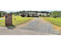Quaint single-story home featuring a long gravel driveway and a lush front lawn at 5333 Lake Glenn Dr, Stanfield, NC 28163