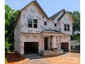 New construction home with attached garages, framed with Tyvek HomeWrap under a blue sky at 5615 Lantana Ave # B, Charlotte, NC 28205