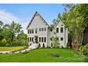 The house offers a well-maintained lawn, white exterior, and professionally landscaped garden enhancing curb appeal at 621 Poindexter Dr, Charlotte, NC 28209