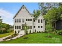 The exterior of this home showcases a manicured lawn, elegant white facade, and striking architectural details at 621 Poindexter Dr, Charlotte, NC 28209