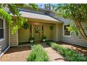 Inviting front entrance with manicured landscaping, hanging plants, and a welcoming wreath on the front door at 7204 E 218 Hwy, Marshville, NC 28103
