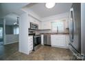 Well-lit kitchen featuring stainless steel appliances, white cabinetry, and tile flooring at 8125 Sheringham Way, Charlotte, NC 28227