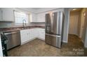 Modern kitchen featuring stainless steel refrigerator, ample counter space, and tile flooring at 8125 Sheringham Way, Charlotte, NC 28227