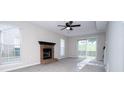 Bright living room featuring a cozy fireplace, neutral paint, and sliding glass door to the backyard at 8125 Sheringham Way, Charlotte, NC 28227