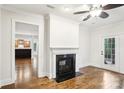 Living room featuring hardwood floors, fireplace, and access to the kitchen and outdoor patio at 8521 Aspen Ct, Charlotte, NC 28227