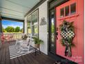 Inviting front porch with rocking chairs, welcome sign, and decorative wreath on the pink front door at 909 Herrons Ferry Rd, Rock Hill, SC 29730