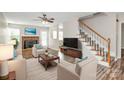 Inviting living room with a brick fireplace, plush seating, and elegant staircase at 10945 Wiltshire Ln, Charlotte, NC 28262