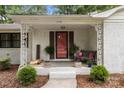 Inviting front porch with decorative columns, a brick facade, and a vibrant red door at 1109 S Highland Ave, Landis, NC 28088