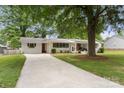 Inviting single-story home featuring white brick, dark shutters, and a spacious driveway at 1109 S Highland Ave, Landis, NC 28088