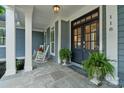 Inviting front porch with rocking chairs and double doors at 118 Tuscany Trl, Mooresville, NC 28117