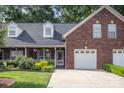 Inviting brick home with dormer windows, a well-kept lawn, and an attached garage at 121 Quality Dr, Mount Holly, NC 28120