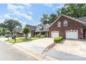 Brick townhome exterior with two car garage and manicured lawn at 121 Quality Dr, Mount Holly, NC 28120
