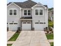 Well-manicured townhouse with a driveway, three garages, and stone detailing at 13327 Savaine St, Charlotte, NC 28278