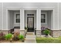 Inviting front porch featuring stone accents, a cozy bench, and decorative potted plants at 13327 Savaine St, Charlotte, NC 28278