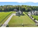 Expansive aerial view of a luxurious home with a large, well-manicured lawn and a gated entrance at 1405 Waxhaw Marvin Rd, Waxhaw, NC 28173