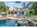 Stunning backyard oasis with pool, spa with waterfall feature and covered patio seating area at 167 Quaker Rd, Mooresville, NC 28117