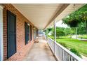 Inviting covered porch with decorative hanging plants and a view of the landscaped yard at 2728 Touchstone Cir, Newton, NC 28658