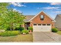 Charming brick front home features a well-manicured lawn, inviting entrance, and an attached two-car garage at 417 Brier Knob Dr, Fort Mill, SC 29715