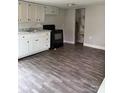 Galley kitchen with white cabinets, black appliances, laminate counters, and gray wood-look floors at 4417 Grier St, Gastonia, NC 28056