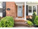 Inviting entryway with a stylish front door, brick accents, and charming landscaping at 4924 Farm Pond Ln, Charlotte, NC 28212