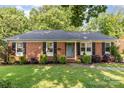 Charming brick home with manicured lawn, lush landscaping, and inviting curb appeal at 4924 Farm Pond Ln, Charlotte, NC 28212