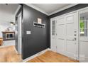 Welcoming entryway with a black accent wall, white trim, and hardwood floors leading to a cozy living space at 5016 Celeste Ct, Charlotte, NC 28270