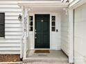 Inviting entryway with a dark green front door, white trim, sidelights, and a covered porch area at 5016 Celeste Ct, Charlotte, NC 28270