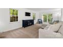 Bright living room with plush carpeting, white walls, large windows, and a comfortable seating area at 5016 Celeste Ct, Charlotte, NC 28270