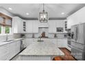 Bright kitchen with white cabinets, stainless steel appliances, large island, and modern lighting at 5044 Dockside Ct, Matthews, NC 28104