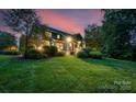 Well-maintained home exterior with lush lawn, professional landscaping, and a private backyard at twilight at 5044 Dockside Ct, Matthews, NC 28104