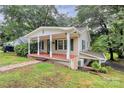 Charming home with cozy covered porch, green shutters and leafy trees at 613 N Rhyne St, Gastonia, NC 28054