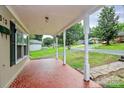 Inviting covered front porch featuring a unique red mosaic tile floor at 613 N Rhyne St, Gastonia, NC 28054