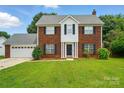Charming brick two-story home with a well-manicured lawn and attached two-car garage at 6821 Millingden Ct, Charlotte, NC 28277