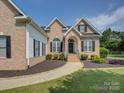 Well-maintained brick home with black shutters, tidy landscaping, and a walkway to the front door at 736 Creekbridge Dr, Rock Hill, SC 29732