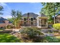 Expansive backyard featuring a lush lawn, a patio, a water feature and an enclosed gazebo at 9219 Whispering Wind Dr, Charlotte, NC 28277