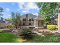 Beautiful backyard featuring a deck, screened porch, and well-maintained landscaping at 9219 Whispering Wind Dr, Charlotte, NC 28277