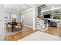 Dining area featuring a black table, seating for eight, and an adjacent living room with stairs at 9219 Whispering Wind Dr, Charlotte, NC 28277
