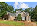 Lovely two-story brick home with a well-manicured lawn and mature trees at 9219 Whispering Wind Dr, Charlotte, NC 28277