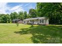 Well-maintained home with a spacious yard and inviting front porch, perfect for outdoor enjoyment at 103 Poplar Trl, Rockwell, NC 28138