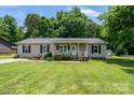 Charming home featuring a well-manicured lawn, cozy front porch, and classic curb appeal at 103 Poplar Trl, Rockwell, NC 28138
