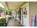 Inviting front porch features rocking chairs and seasonal decor, adding a touch of charm at 103 Poplar Trl, Rockwell, NC 28138