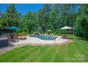 Luxurious backyard featuring a freeform pool, waterfall, and mature trees at 1085 Wessington Manor Ln, Fort Mill, SC 29715